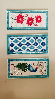 three decorative wall hangings with flowers and peacocks on each one, in different colors