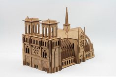 a wooden model of a church with steeples and spires on the front, against a white background