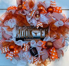 an orange and white mesh wreath with the words hook'em on it