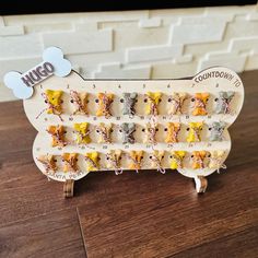 a dog shaped wooden calendar with dogs on it's sides and the word woo written in small letters