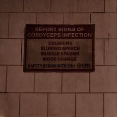 a sign that is on the side of a brick wall reading report signs of corrodypes infection