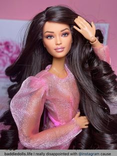 a barbie doll with long black hair wearing a pink dress and holding her hand up to her head