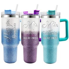 three personalized travel mugs with matching lids and handles, one is blue, the other has purple