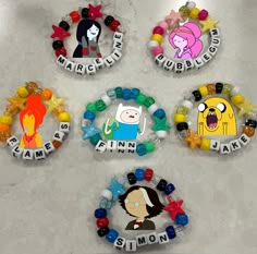 four badges with cartoon characters on them sitting on a counter top next to each other