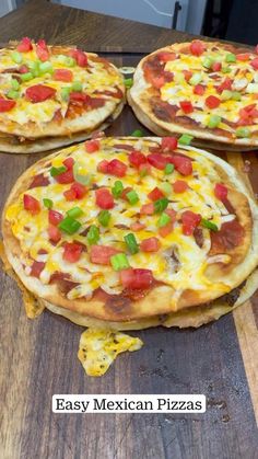 three pizzas sitting on top of a wooden table