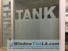 a window with the word tank written on it in front of an office cubicle