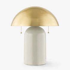 a white table lamp with a gold dome shade