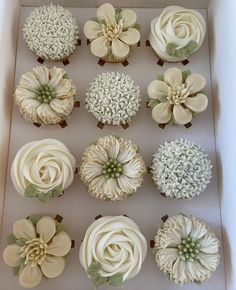 twelve cupcakes in a box decorated with flowers