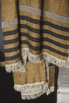 a brown and black striped blanket hanging from a window