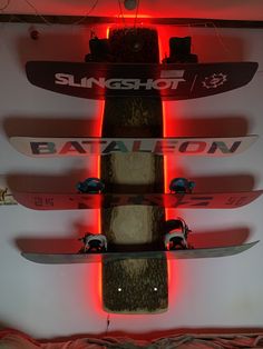 three snowboards mounted to the ceiling with red lights