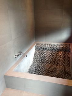 a bathtub in the corner of a tiled bathroom