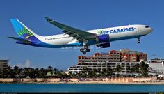 an airplane is flying low over the water and buildings on the beach in front of it