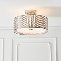 a light fixture hanging from the ceiling in a room with white walls and flooring