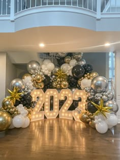 a large balloon arch with the number 20 on it and balloons in the shape of letters