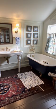 a bathroom with a rug, sink and bathtub in the middle of the room