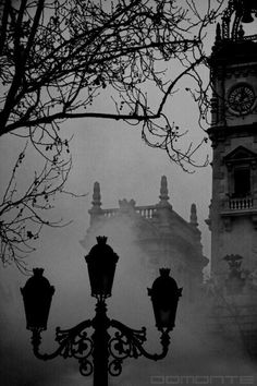 black and white photograph of clock tower in fog