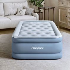 an inflatable mattress sitting on the floor next to a couch