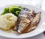 a white plate topped with fish next to mashed potatoes and broccoli