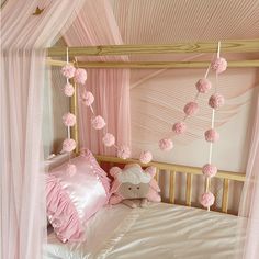 a bed with pink and white decorations on the headboard, pillows, and blanket