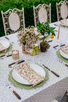 the table is set with plates and place settings