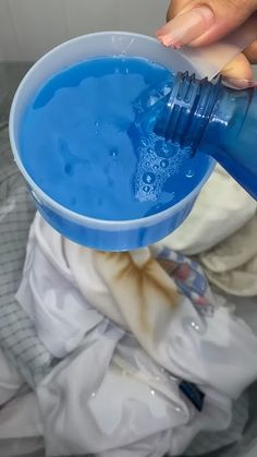 a person pouring blue liquid into a bowl