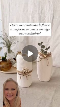 a woman sitting in front of two white vases