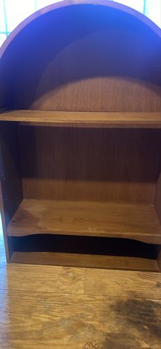 an empty wooden shelf in front of a window