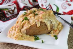 a white plate topped with mashed potatoes covered in gravy and green onions