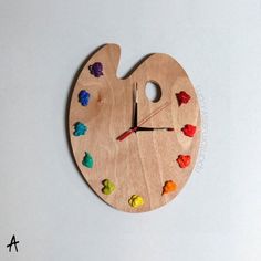 a wooden clock with colorful candies painted on it's face and the hands