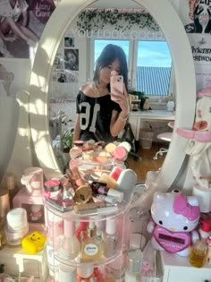 a woman taking a selfie in front of a mirror with hello kitty products on it