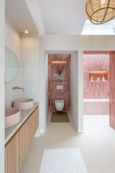 a bathroom with pink and white tiles on the walls