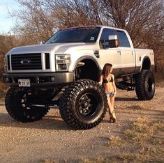 a woman standing next to a white truck