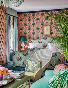 a living room filled with lots of furniture and walls covered in wall coverings next to a window