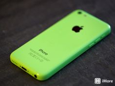 an iphone is sitting on a table with its back turned to the camera and it's green color