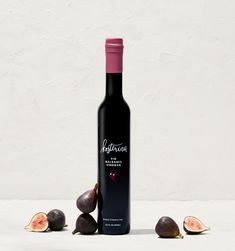 a bottle of wine with some figs around it