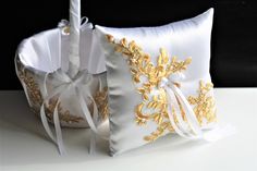 two white and gold decorative pillows with bows on the sides, one has a candle in it