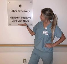 a woman in scrubs standing next to a sign that says labor and delivery newborn intensive care unit nicu