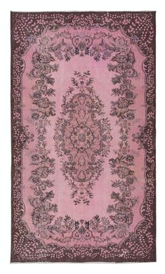 a pink rug with an ornate design on the center and sides, in various colors