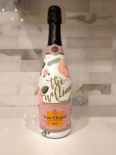 a bottle of wine sitting on top of a counter next to a tile backsplash