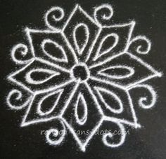 a white drawing on a black surface with swirls and circles in the shape of a snowflake