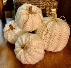 white crocheted pumpkins sitting on top of a wooden table