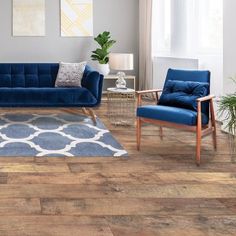 a living room with wood floors and blue furniture