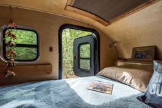 the inside of a camper with a bed, pillows and pictures on the wall