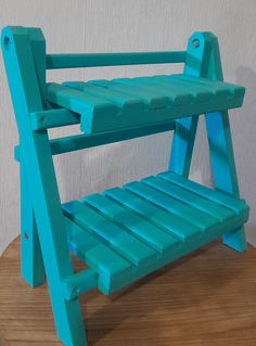 a blue plastic chair sitting on top of a wooden table