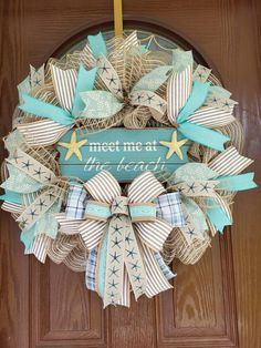 a wreath that says meet me at the beach with blue and white bows on it