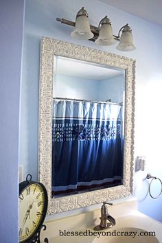 a bathroom sink with a mirror above it and a clock on the wall next to it