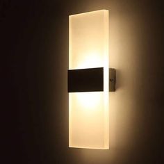 a wall light that is on the side of a wall in a dark room at night