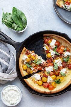 a pizza sitting on top of a pan covered in cheese and toppings next to other food