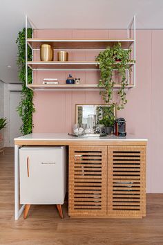 a kitchen with pink walls and wooden shelves