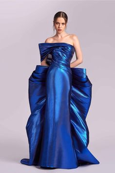 Elevate your style with this stunning metallic blue strapless dress. Featuring a sculpted, pleated bodice, it elegantly drapes on both sides, flowing into a structured silhouette. The gathered train at the back adds a touch of drama, making this dress perfect for any special occasion. Shine with confidence! Blue Strapless Dress, Blue Evening Dresses, Pleated Bodice, Metallic Blue, Evening Dress